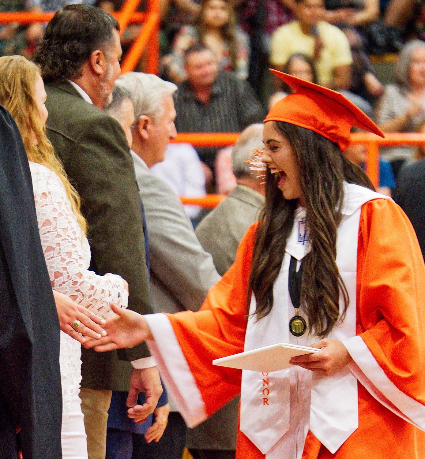 Alana Galaz shares a congratulatory moment of jubilation with school board member Jackie Rodieck. [more moments of Mineola grads]
